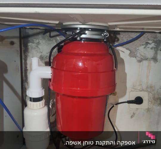 מתקן אדום מתחת לכיור עם צינורות וחיבורים